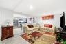 Living area featuring wood-finish flooring, recessed lighting, and a horizontal window, with built-in cabinetry and stainless steel appliances in the 