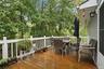 Wood-plank deck featuring white railing and attached exterior lighting