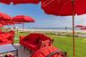 Manicured lawn bordered by a sand shoreline and oceanfront horizon
