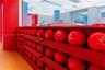 Built-in tiered red shelving unit featuring wood-finish flooring and integrated recessed ceiling lighting