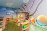 Custom interior featuring architectural wall treatments, built-in curved shelving units, recessed circular illuminated wall niches, and bespoke suspen