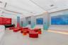 Modern interior space featuring an expansive ceiling with integrated recessed lighting, built-in tiered perimeter seating, smooth-finish flooring, and