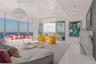 Floor-to-ceiling windows, polished stone flooring, custom stone-clad fireplace surround, recessed ceiling lighting, and pendant globe fixtures