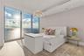 Floor-to-ceiling windows featuring ocean scenery, wood-finish flooring, recessed lighting, and a textured wall finish