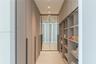 Custom storage solution featuring floor-to-ceiling cabinetry with textured diamond-patterned doors, integrated full-height mirrors, extensive open she