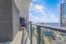 Covered balcony featuring tile flooring, glass panel railings, and a built-in outdoor kitchen station