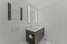 Wall-mounted dark wood-finish vanity with stone countertop, integrated sink, LED-lit mirror, built-in glass shelving, and wall-mounted dual-flush actu
