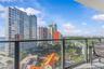 Private balcony featuring metal railing and glass panels with urban and water surroundings