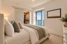 Glass sliding closet door, walk-in wardrobe with built-in shelving, floor-to-ceiling glass door, and balcony with exterior railing