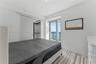 Room featuring tile flooring, sliding glass door access to a balcony, and a built-in walk-in closet with integrated shelving