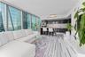 Floor-to-ceiling windows, high-gloss cabinetry, linear-patterned tile flooring, integrated kitchen appliances, and stone-topped kitchen island