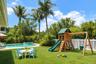 Backyard featuring a swimming pool, integrated spa, perimeter vinyl fencing, and mature palm trees