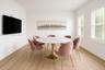 Bright room featuring wood-finish flooring, dual windows with plantation shutters, and crown molding