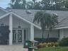 Exterior entrance featuring dual glass-panel doors with geometric detailing, gabled roofline, integrated skylights, and a covered portico with square 