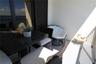 Covered balcony featuring concrete flooring, textured walls, metal railing, and sliding glass door access