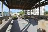 Covered wooden gazebo featuring built-in bench seating, plank flooring, and a decorative tile inlay