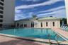 Outdoor swimming pool featuring a paved deck and a clubhouse with a metal roof