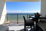 Covered balcony featuring a metal railing and ocean backdrop