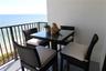Balcony featuring metal railings and a textured exterior wall finish, overlooking an oceanfront landscape