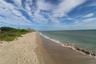Sandy beach shoreline featuring natural coastal vegetation and direct ocean water frontage