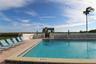 Rectangular swimming pool featuring tile coping, a paver deck, and perimeter masonry wall