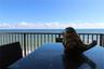 Private balcony featuring a metal railing and ocean backdrop