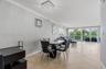 Open-concept interior featuring large-format tile flooring, crown molding, a crystal-accented flush mount light fixture, and floor-to-ceiling glass sl