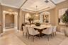 Dining area featuring a tray ceiling, recessed alcove with glass shelving, arched entryways, and crown molding