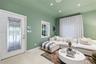 Entry area featuring a glass-inset door with geometric detailing, recessed ceiling lighting, tray ceiling architecture, large-format tile flooring, an