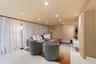 Interior space featuring large-format tile flooring, recessed ceiling lighting, a wall-mounted floating media console, and vertical wood-slat wall pan