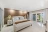 Textured wood-slat accent wall, polished large-format tile flooring, and glass-paned double doors with integrated window treatments