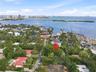Aerial perspective of a coastal parcel featuring mature canopy trees, waterfront proximity, and established neighborhood foliage