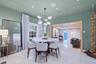 Polished tile flooring, modern multi-arm chandelier with glass globe shades, recessed ceiling lighting, and custom wide-cased door frame