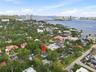 Aerial perspective of a residential property featuring mature landscaping, a swimming pool, and established trees within a coastal neighborhood