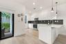 Kitchen featuring flat-panel white cabinetry, stone-finish countertops, stainless steel appliances, a dark mosaic tile backsplash, and wood-finish flo