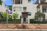 Stucco exterior featuring multi-level balconies, stone-accented entryway, tile roofing, and metal perimeter fencing