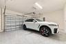 Enclosed garage featuring finished epoxy flooring, automated door mechanism, and overhead lighting