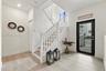 Foyer featuring wood-finish flooring, a glass-panel entry door, and a staircase with white painted balusters and wood-finish treads