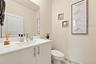 White vanity cabinet with an integrated countertop and sink, chrome single-handle faucet, and large wall-mounted mirror