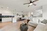 Kitchen featuring white flat-panel cabinetry, a dark tile backsplash, and a central island with countertop seating, complemented by wood-finish floori
