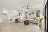 Open-concept interior featuring wood-finish flooring, a white staircase with a vertical balustrade, recessed lighting, a ceiling fan with integrated l