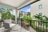 Covered balcony featuring concrete flooring, black metal railing, and a textured stucco ceiling