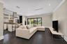 Open-concept living space featuring wood-finish flooring, recessed lighting, crown molding, and multi-panel sliding glass doors