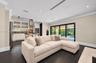 Kitchen featuring custom white cabinetry with glass-front uppers, stainless steel appliances, stone-tile backsplash, and wood-finish flooring, complem