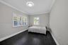 Dark wood-finish flooring, crisp crown molding, and plantation shutters throughout