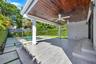 Covered patio featuring a stained wood plank ceiling, dual ceiling fans, tile flooring, and step access to the pool area with paver hardscaping