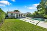 Backyard featuring a swimming pool, concrete paver patio with turf inlays, manicured lawn, and perimeter hedging
