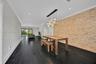 Textured stone accent wall, multi-pendant light fixture, wood-finish flooring, and recessed ceiling lighting