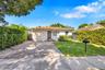 Exterior featuring a stucco facade, clay tile roof, paver driveway, and manicured landscaping