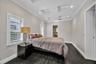Coffered ceiling featuring recessed lighting, white plantation shutters, and dark wood-finish tile flooring